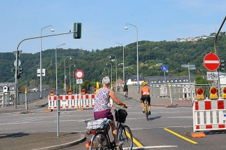 Radfahrerinnen und Radfahrer überqueren die autofreie Römerbrücke zu Beginn der aktuellen Bauarbeiten.